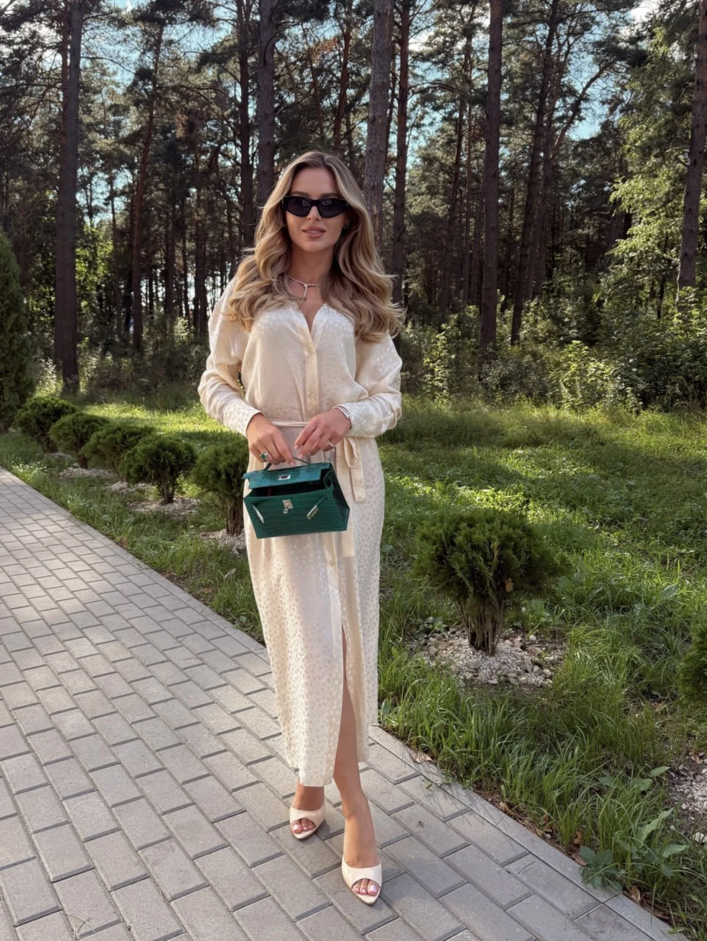 Julia outdoors wearing an ivory dress and sunglasses